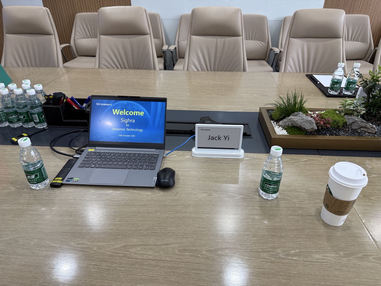 客户接待会议现场,桌面摆放方案演示电脑、姓名牌与国旗